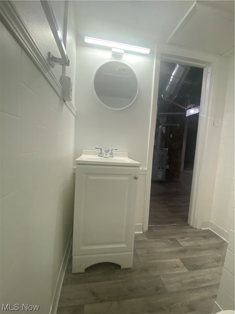 12913 Silver Road Cleveland, OH 44125 - Photo 21 of 23 Basement Bathroom with new floors, mirror, vanity, a shower with shower curtain, and tile walls