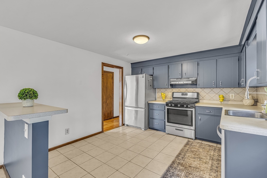 50 Harlow Road Rockland, MA 02370 - Photo 12 of 38 a kitchen with stainless steel appliances granite countertop a stove top oven a sink dishwasher and a refrigerator with wooden floor