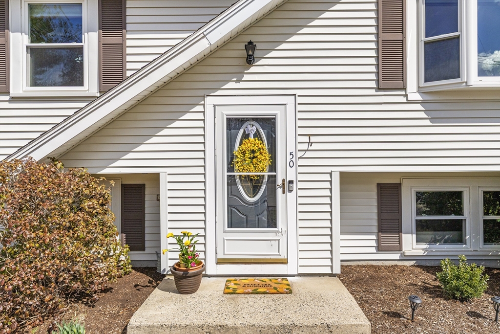 50 Harlow Road Rockland, MA 02370 - Photo 3 of 38 a front view of a house with large windows and potted plants