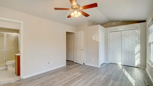a bathroom with a toilet sink vanity and shower
