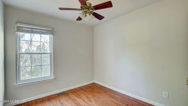 an empty room with a window and a fan