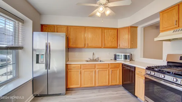 a kitchen with cabinets stainless steel appliances and a window