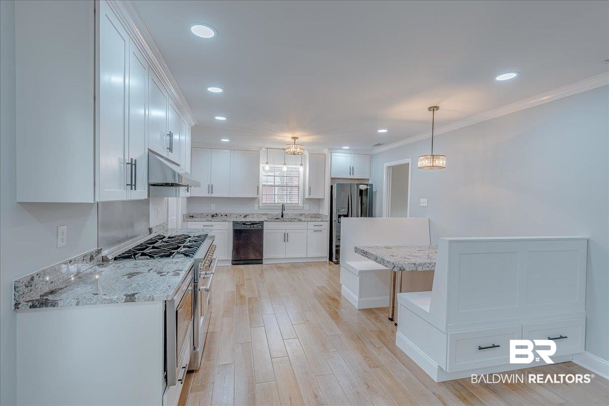 440 Dykes Road Mobile, AL 36608 - Photo 11 of 49 Kitchen featuring light wood finished floors, under cabinet range hood, white cabinets, stainless steel appliances, and a sink