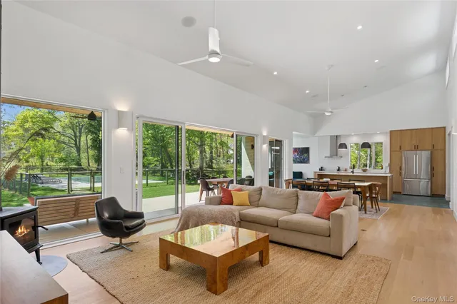 a living room with furniture fireplace and large windows