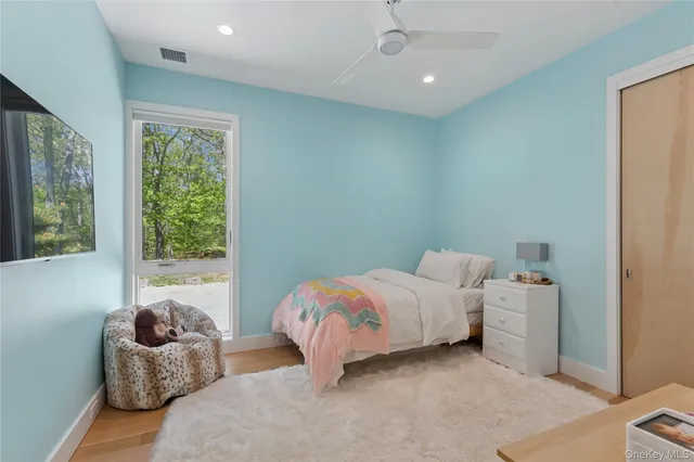 a bedroom with furniture and a large window