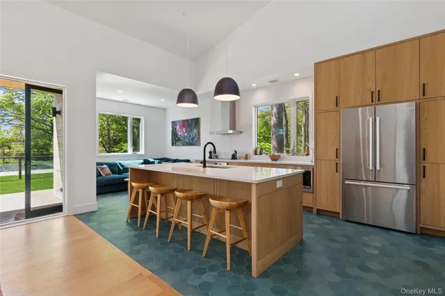 a kitchen with kitchen island granite countertop a sink stainless steel appliances and cabinets