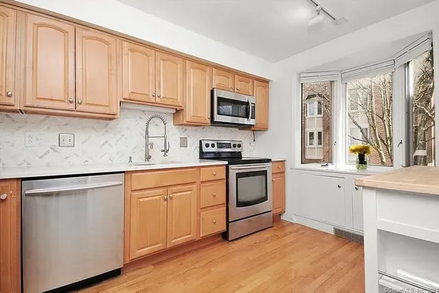 a kitchen with granite countertop cabinets stainless steel appliances and a sink