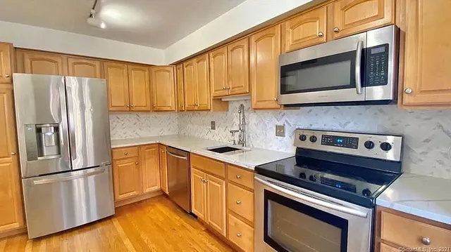 a kitchen with stainless steel appliances a stove microwave and sink