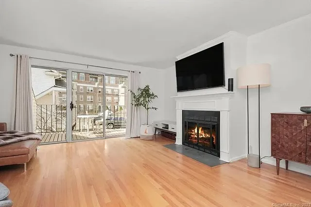 a living room with furniture a flat screen tv and a fireplace