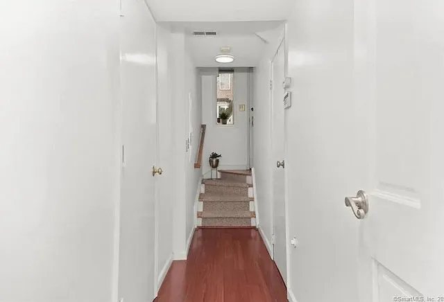 a view of a hallway with wooden floor and staircase
