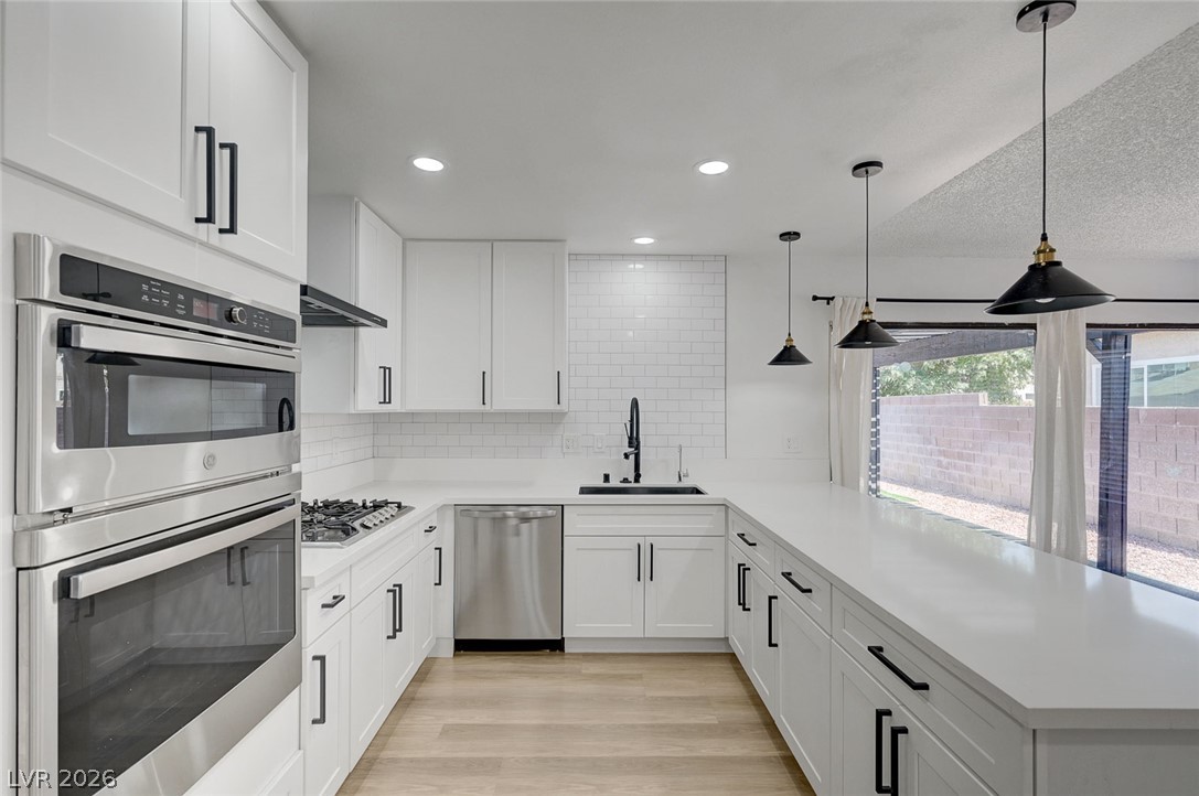 4840 Summerhill Road Las Vegas, NV 89121 - Photo 18 of 56 A contemporary kitchen boasts a U-shaped counter with a sleek, minimalist design.