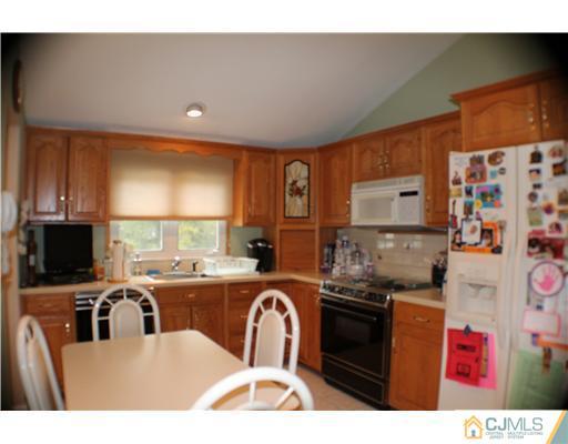 39 Gramercy Road Old Bridge, NJ 08857 - Photo 8 of 20 a kitchen with granite countertop a stove a sink and a refrigerator