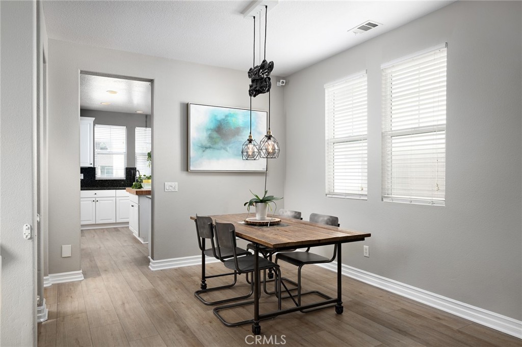 41 Ethereal Ladera Ranch, CA 92694 - Photo 10 of 35 a dining room with wooden floor a chandelier a wooden table and chairs