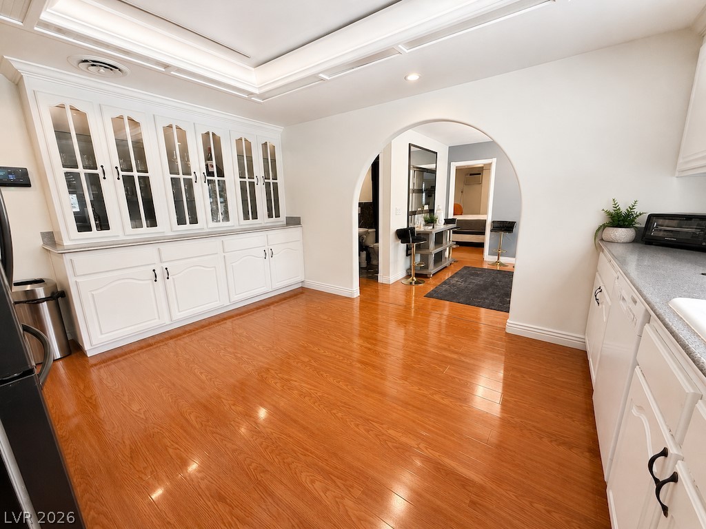 3010 East Viking Road Las Vegas, NV 89121 - Photo 26 of 48 Warm hardwood flooring flows through this bright kitchen, featuring a built-in display cabinet and arched entry.