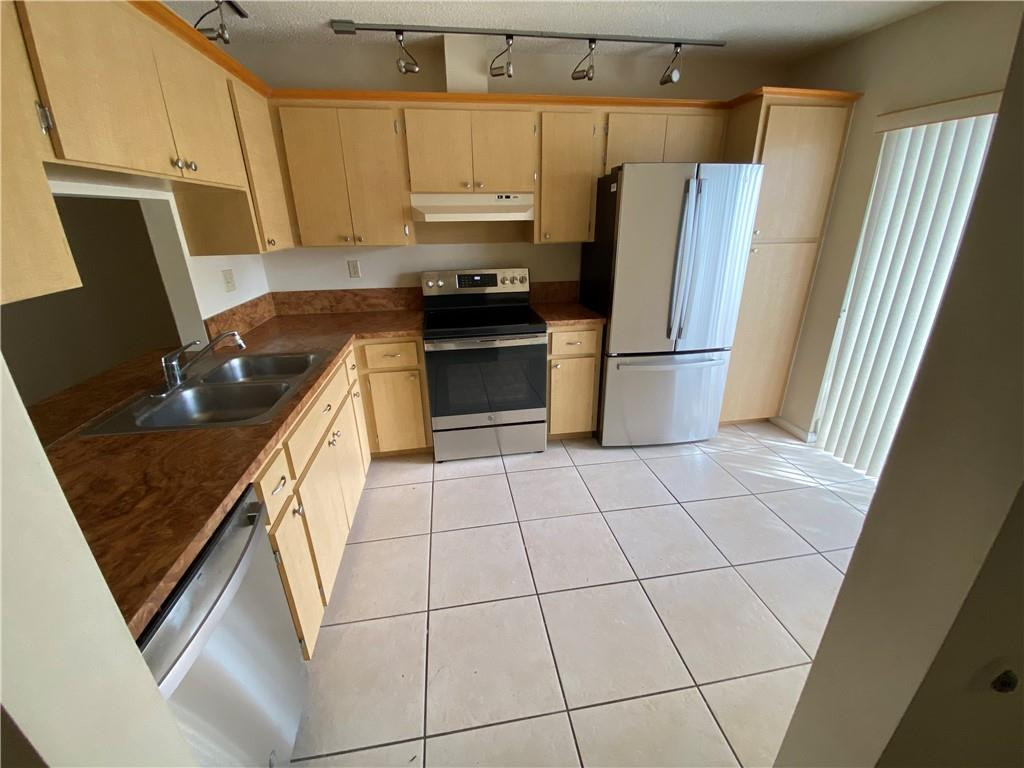 715 Banks Road, Unit 715 Margate, FL 33063 - Photo 3 of 23 a kitchen with a refrigerator a stove a sink and dishwasher