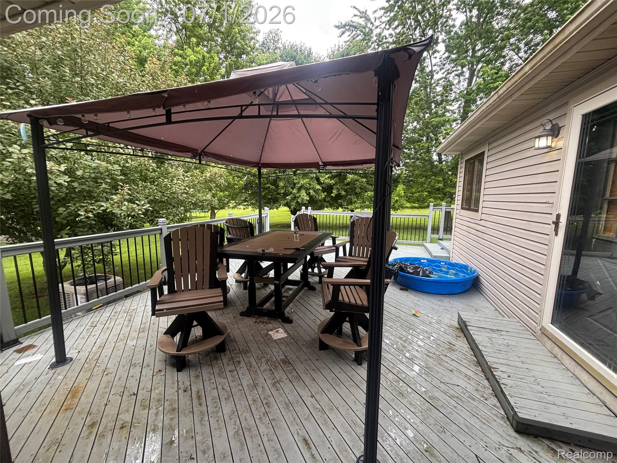 9844 Pine Knob Road Clarkston, MI 48348 - Photo 5 of 15 Spacious outdoor deck featuring light-toned decking, black metal railings, and a large gazebo with a fabric canopy