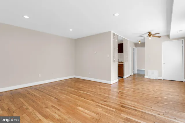 a view of empty room with wooden floor