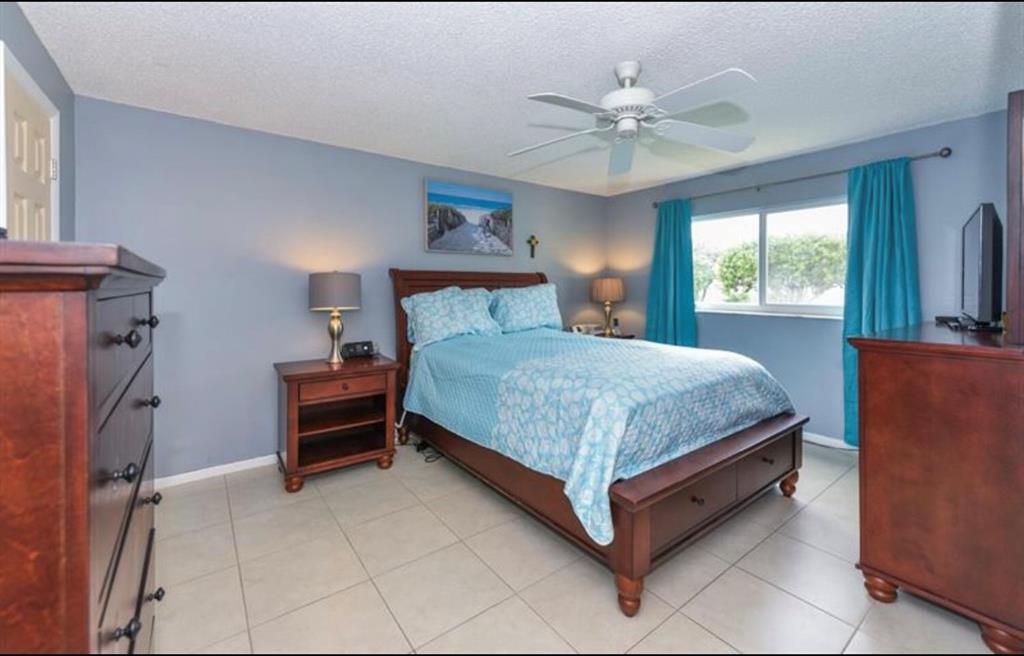 2615 Northeast 3rd Street, Unit 217 Boynton Beach, FL 33435 - Photo 16 of 55 a bedroom with a bed and a chandelier