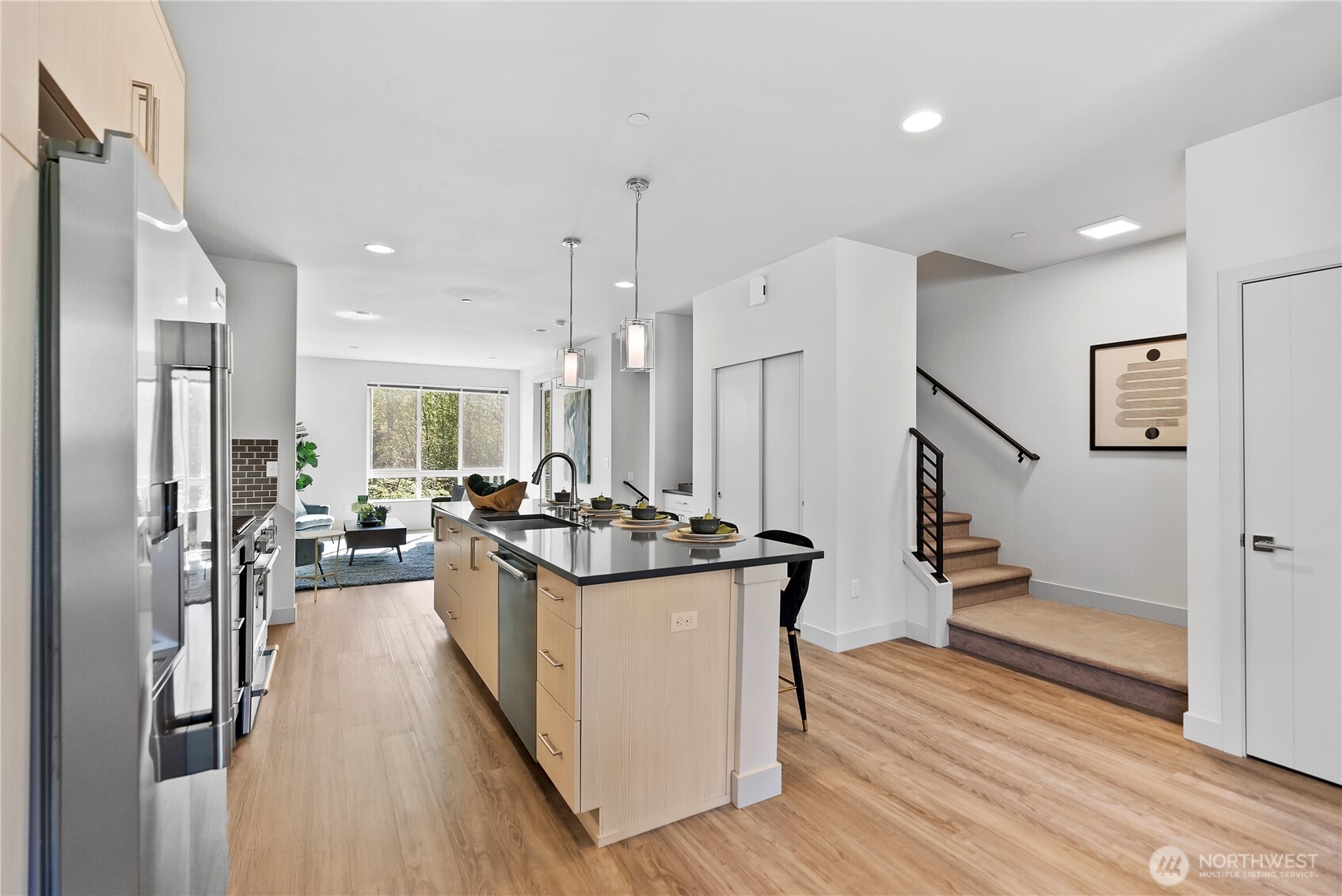 17905 35th Avenue Southeast, Unit A1 Bothell, WA 98012 - Photo 10 of 36 a kitchen with stainless steel appliances a stove top oven a refrigerator a dining table and chairs with wooden floor