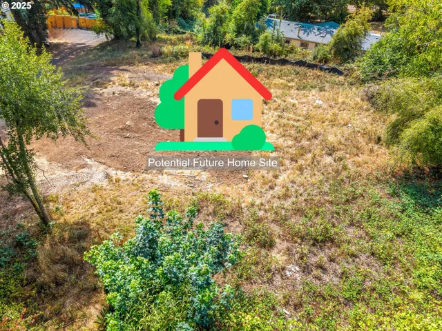 a view of green field with some trees in the background