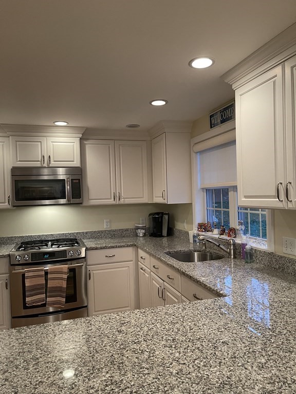 223 Governors Road Quincy, MA 02169 - Photo 9 of 40 a kitchen with stainless steel appliances granite countertop a stove a sink a microwave a refrigerator and cabinets