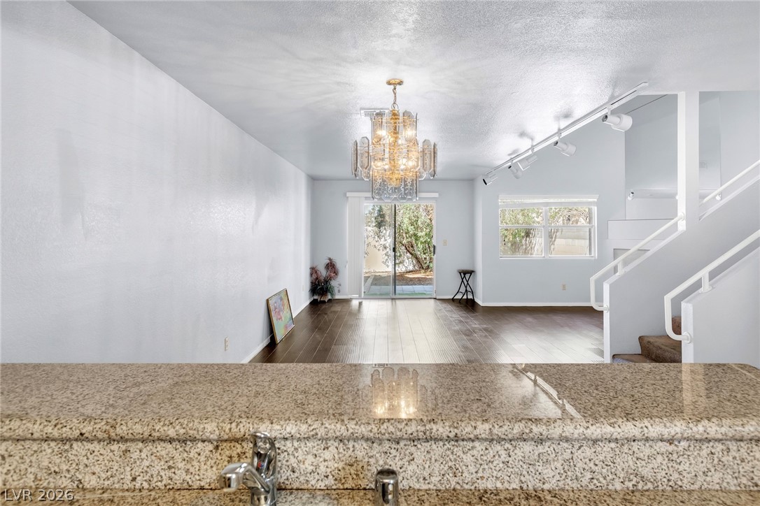 6250 West Flamingo Road, Unit 98 Las Vegas, NV 89103 - Photo 9 of 40 Kitchen featuring rail lighting, baseboards, a chandelier, a textured ceiling, and wood finished floors
