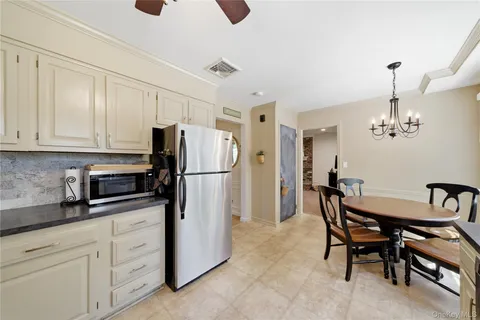 a kitchen with refrigerator cabinets dining table and chairs