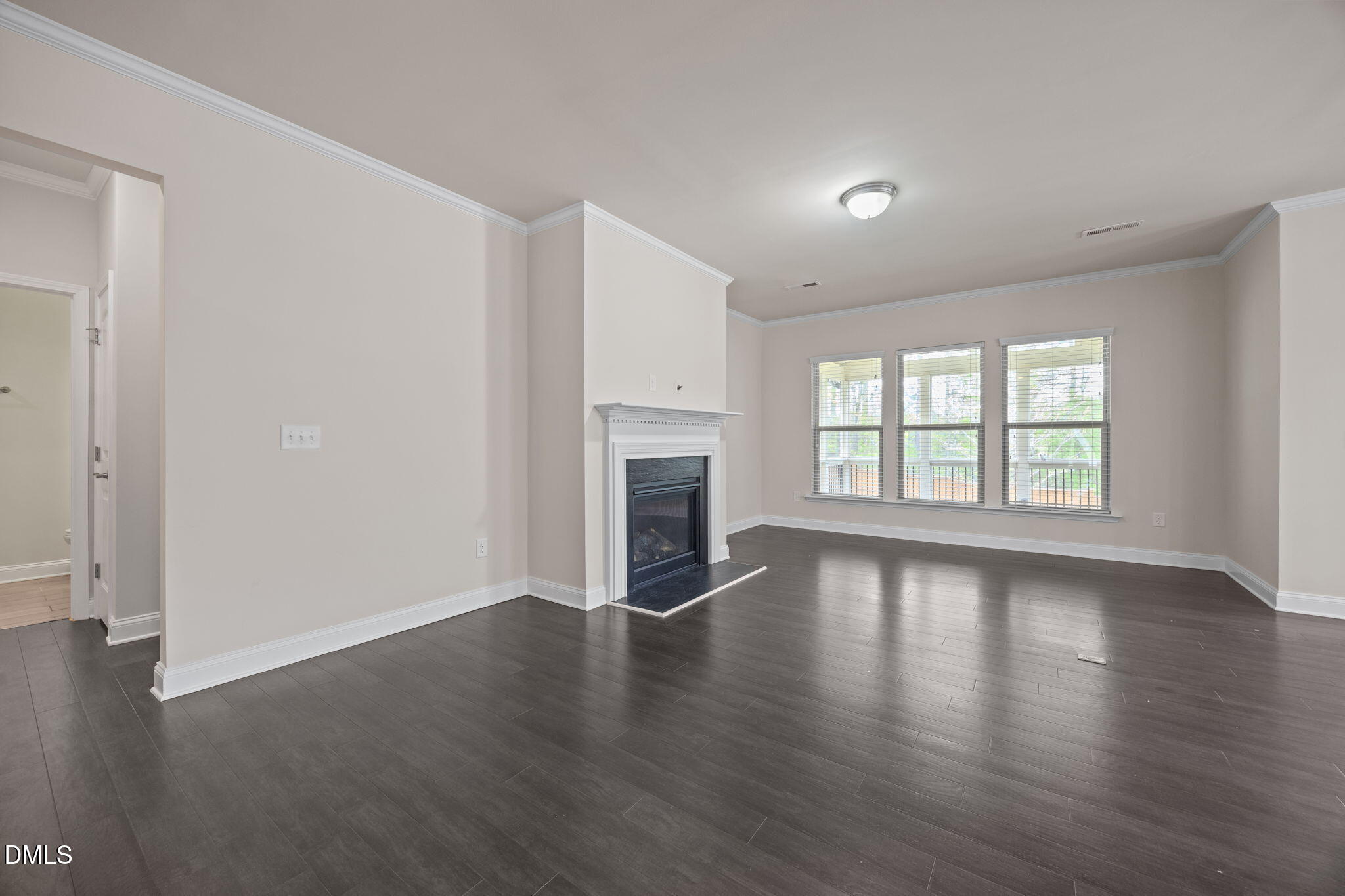 2048 Crampton Grove Way Cary, NC 27519 - Photo 12 of 50 an empty room with wooden floor fireplace and windows