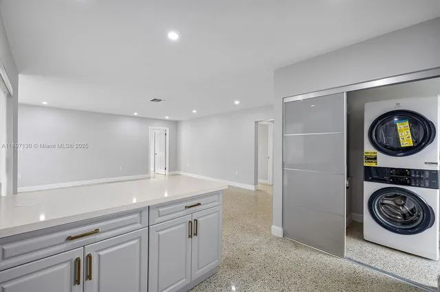a view of a hallway to washer and dryer