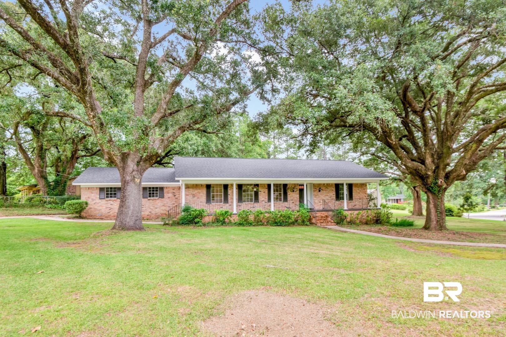 5217 Perin Road Mobile, AL 36693 - Photo 1 of 45 Brick ranch-style residence featuring a dark shingle roof and a covered front porch with white columns