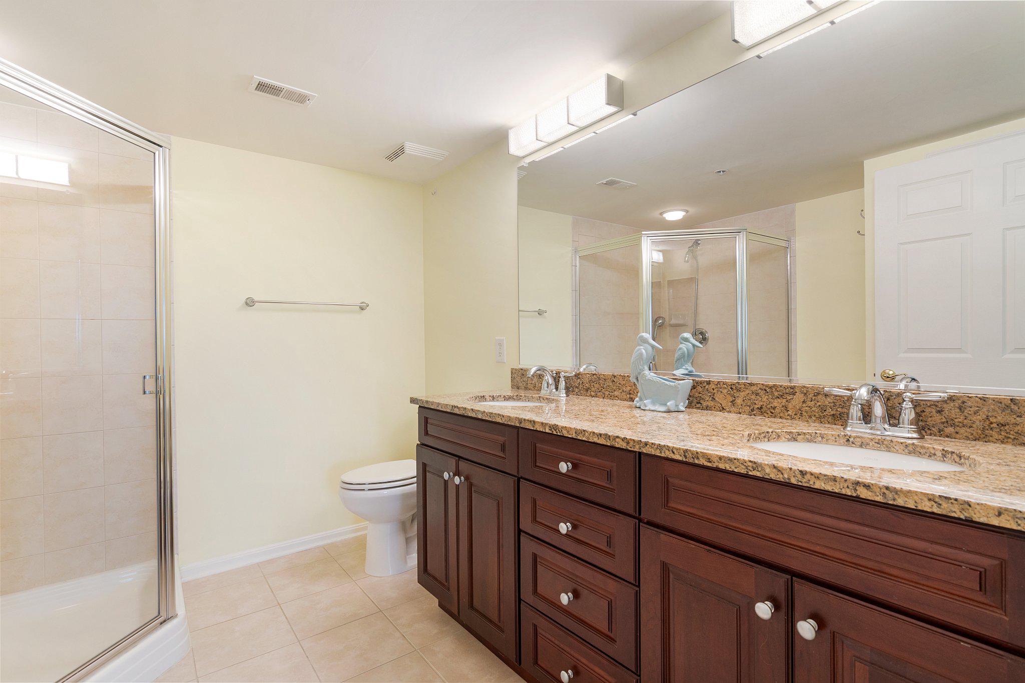 12236 Roundwood Road, Unit 609 Lutherville-Timonium, MD 21093 - Photo 32 of 40 a spacious bathroom with a granite countertop sink a toilet and a mirror