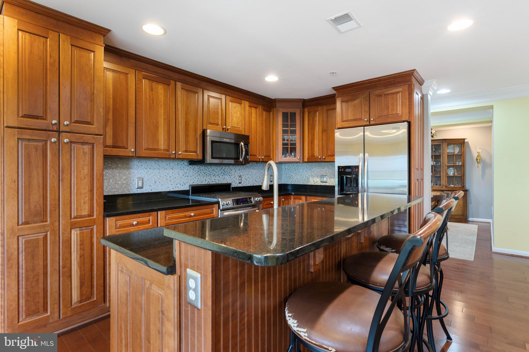 12236 Roundwood Road, Unit 609 Lutherville-Timonium, MD 21093 - Photo 10 of 40 a kitchen with a table chairs refrigerator and cabinets