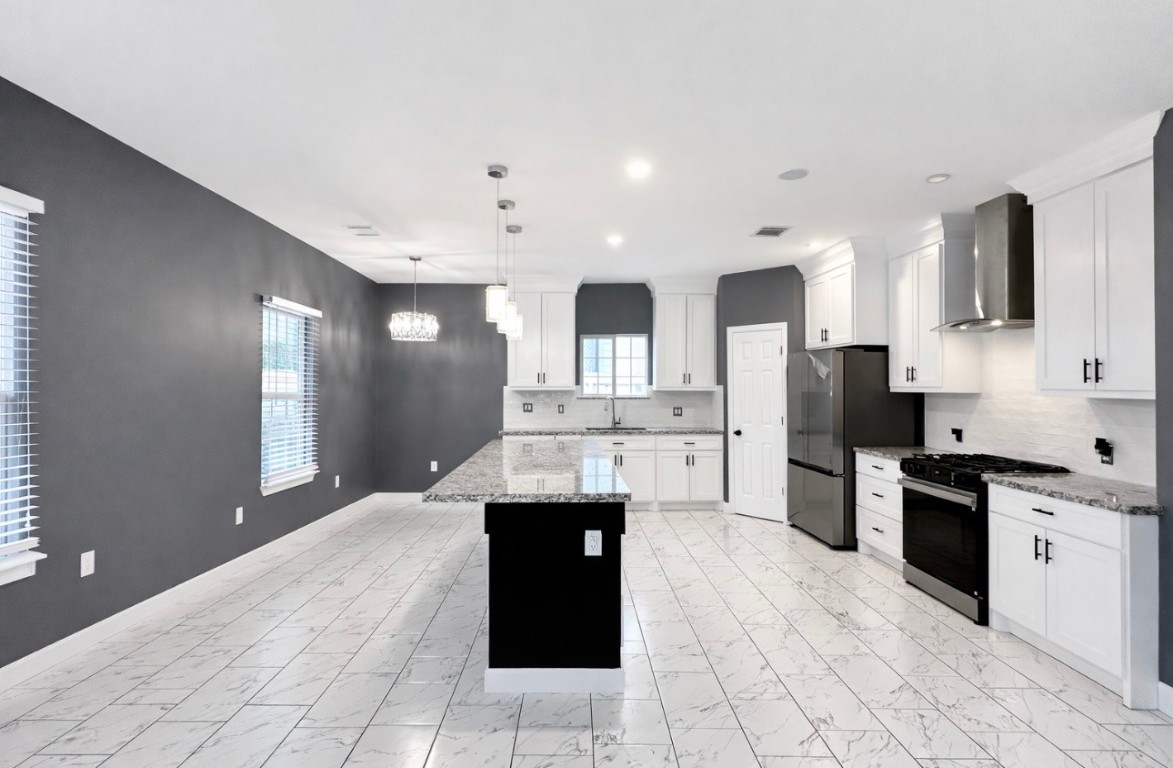 5125 Larkspur Street Houston, TX 77033 - Photo 12 of 33 a kitchen with stainless steel appliances kitchen island granite countertop a refrigerator and a stove top oven