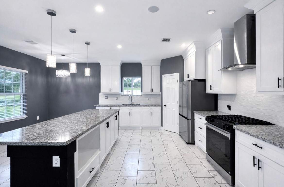 5125 Larkspur Street Houston, TX 77033 - Photo 13 of 33 a kitchen with stainless steel appliances granite countertop a sink stove and refrigerator