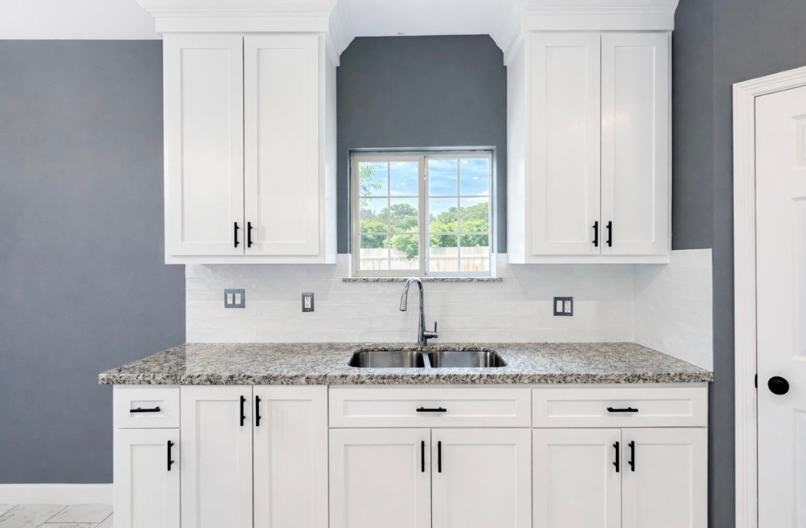 5125 Larkspur Street Houston, TX 77033 - Photo 15 of 33 a kitchen with granite countertop white cabinets and a sink