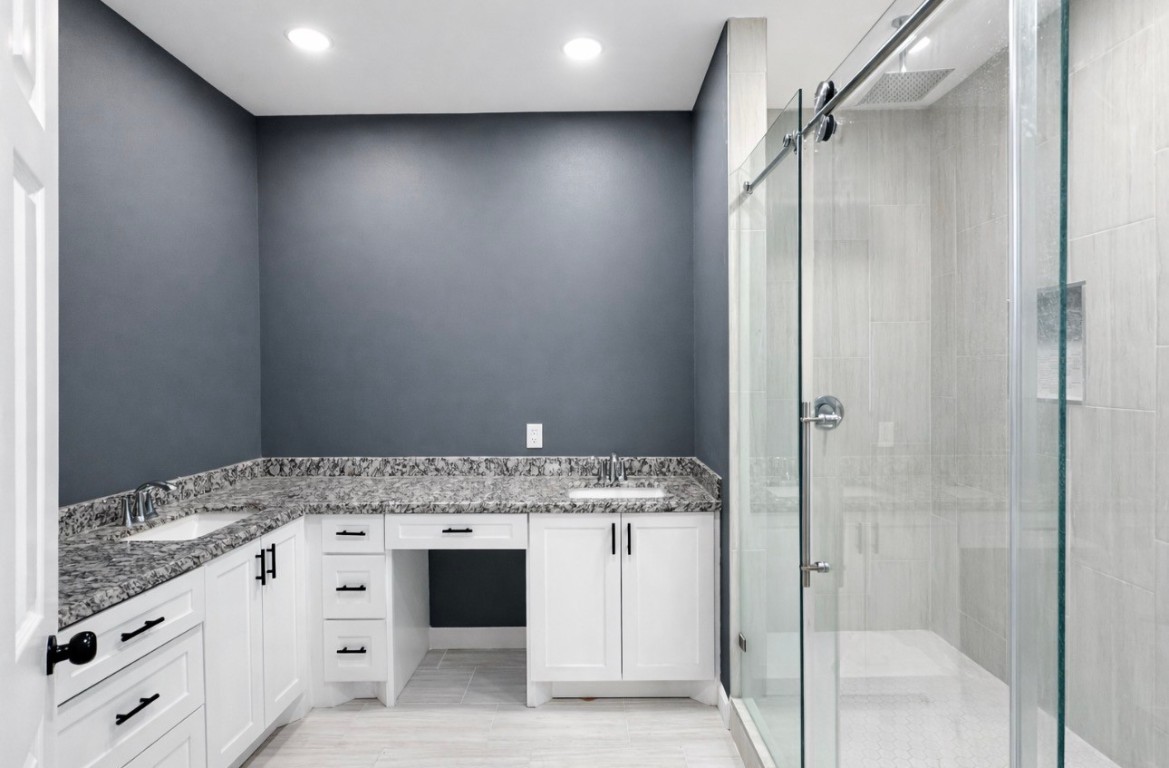 5125 Larkspur Street Houston, TX 77033 - Photo 21 of 33 a bathroom with a granite countertop sink and shower
