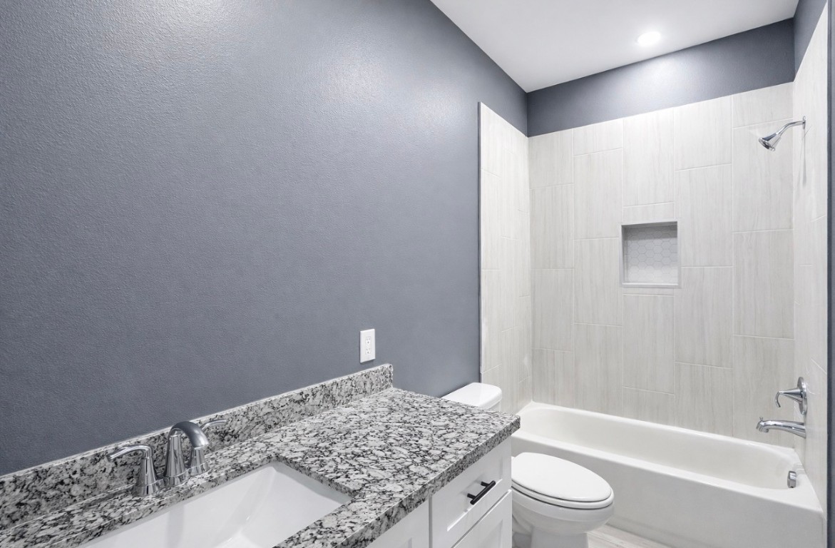 5125 Larkspur Street Houston, TX 77033 - Photo 27 of 33 a bathroom with a granite countertop sink toilet and shower