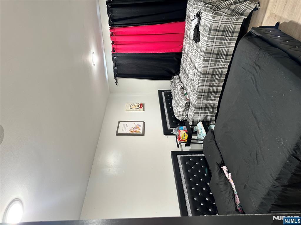 276 Ellison Street Paterson, NJ 07501 - Photo 22 of 22 a bedroom with a bed a dresser and a window