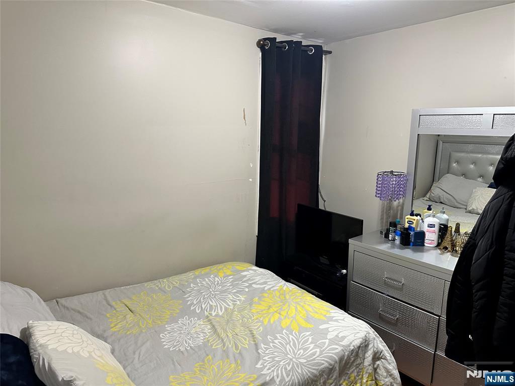 276 Ellison Street Paterson, NJ 07501 - Photo 8 of 22 a bedroom with a bed and a dresser
