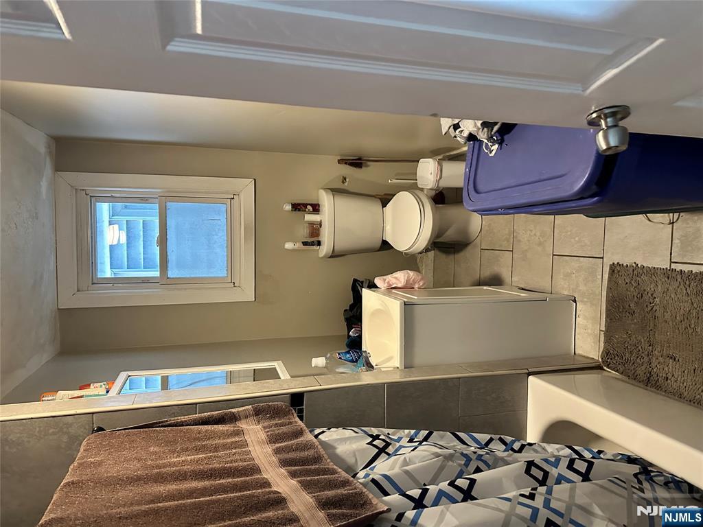 276 Ellison Street Paterson, NJ 07501 - Photo 9 of 22 a bathroom with sink toilet and mirror