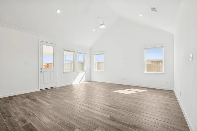 an empty room with wooden floor and windows
