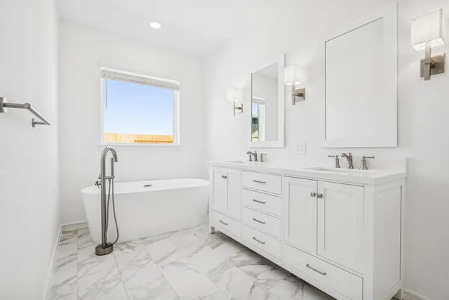 a bathroom with a double vanity sink a mirror and a bathtub
