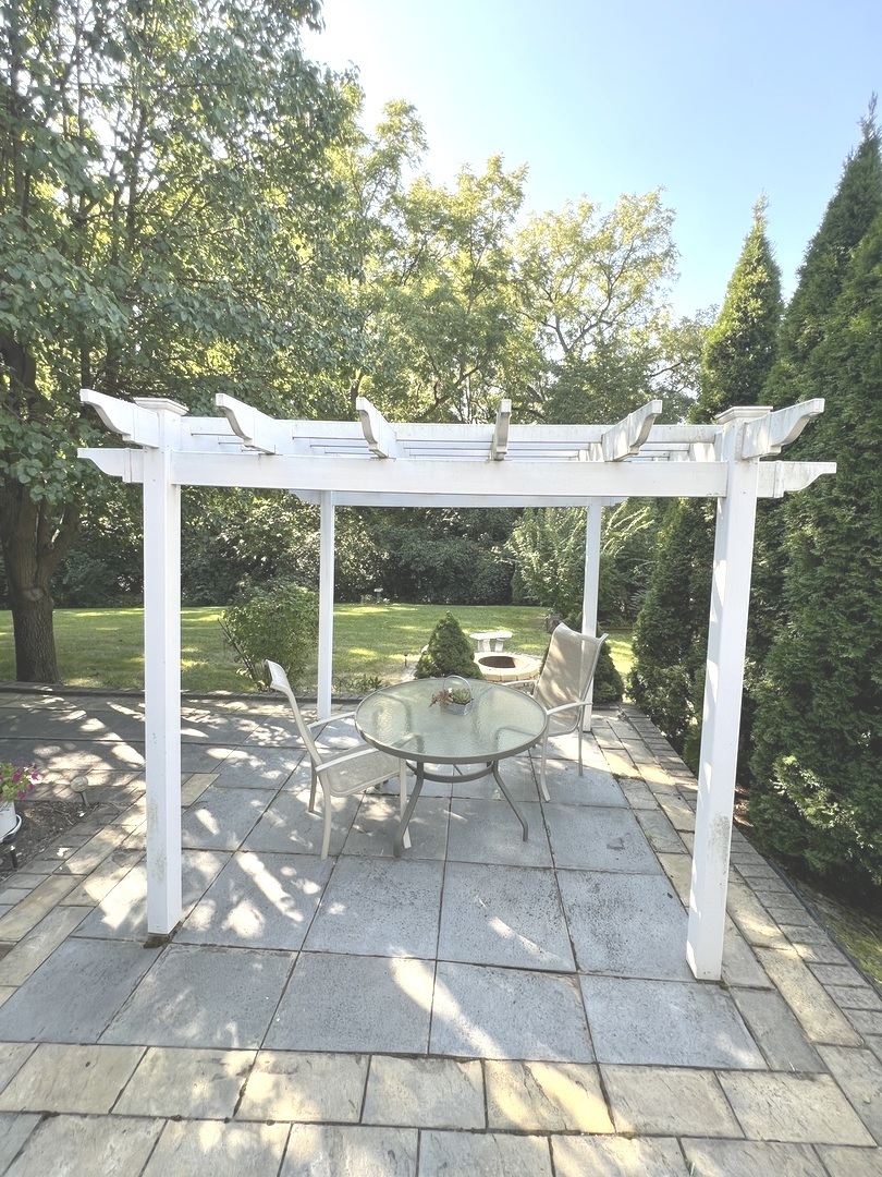 1018 Rain Tree Drive Bolingbrook, IL 60440 - Photo 20 of 22 a view of a patio with a table chairs and a floor to ceiling window