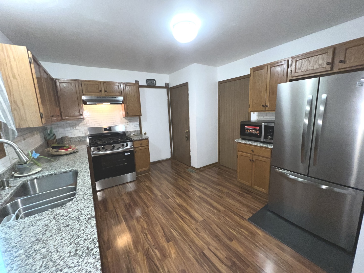 1018 Rain Tree Drive Bolingbrook, IL 60440 - Photo 9 of 22 a kitchen with stainless steel appliances granite countertop a refrigerator stove and sink