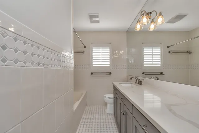 a bathroom with double vanity and a bathtub