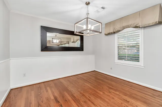 a view of a room with wooden floor ceiling fan and windows