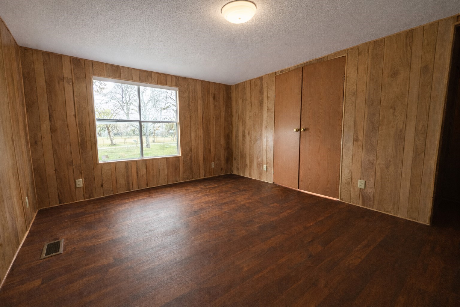 1037 Pecan Valley Road Wharton, TX 77488 - Photo 11 of 17 a view of an empty room with wooden floor and a window