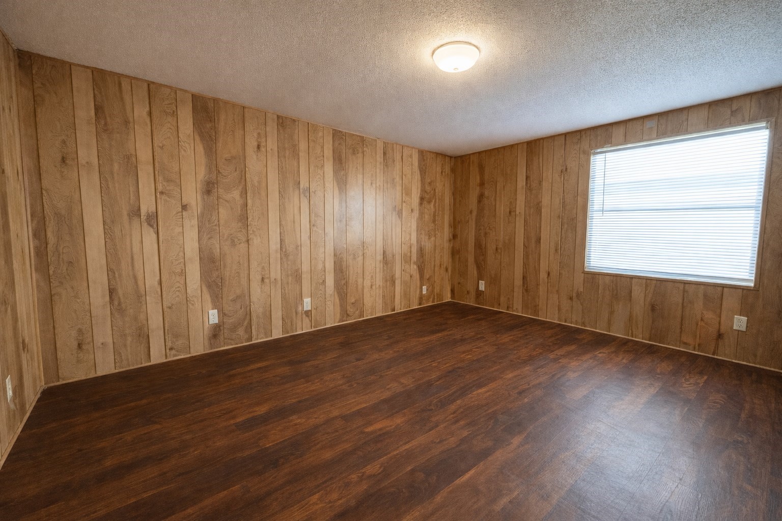 1037 Pecan Valley Road Wharton, TX 77488 - Photo 9 of 17 an empty room with wooden floor and windows with curtains