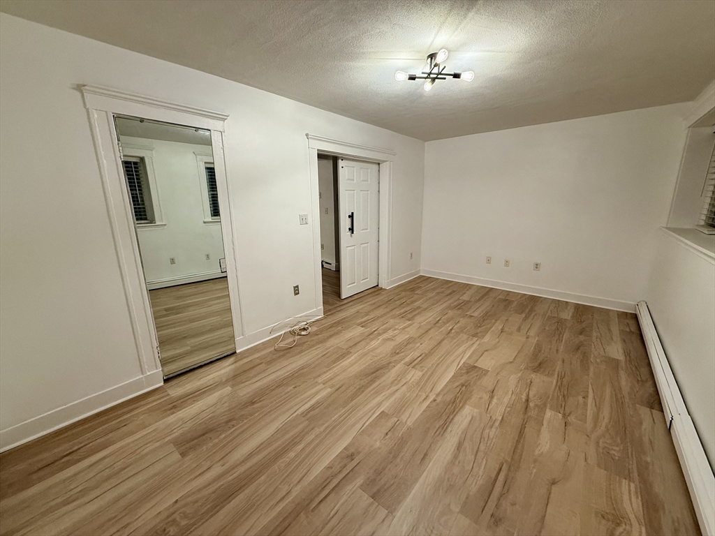 28 Ransom Road, Unit 12AB Boston, MA 02135 - Photo 11 of 17 wooden floor in an empty room with a window