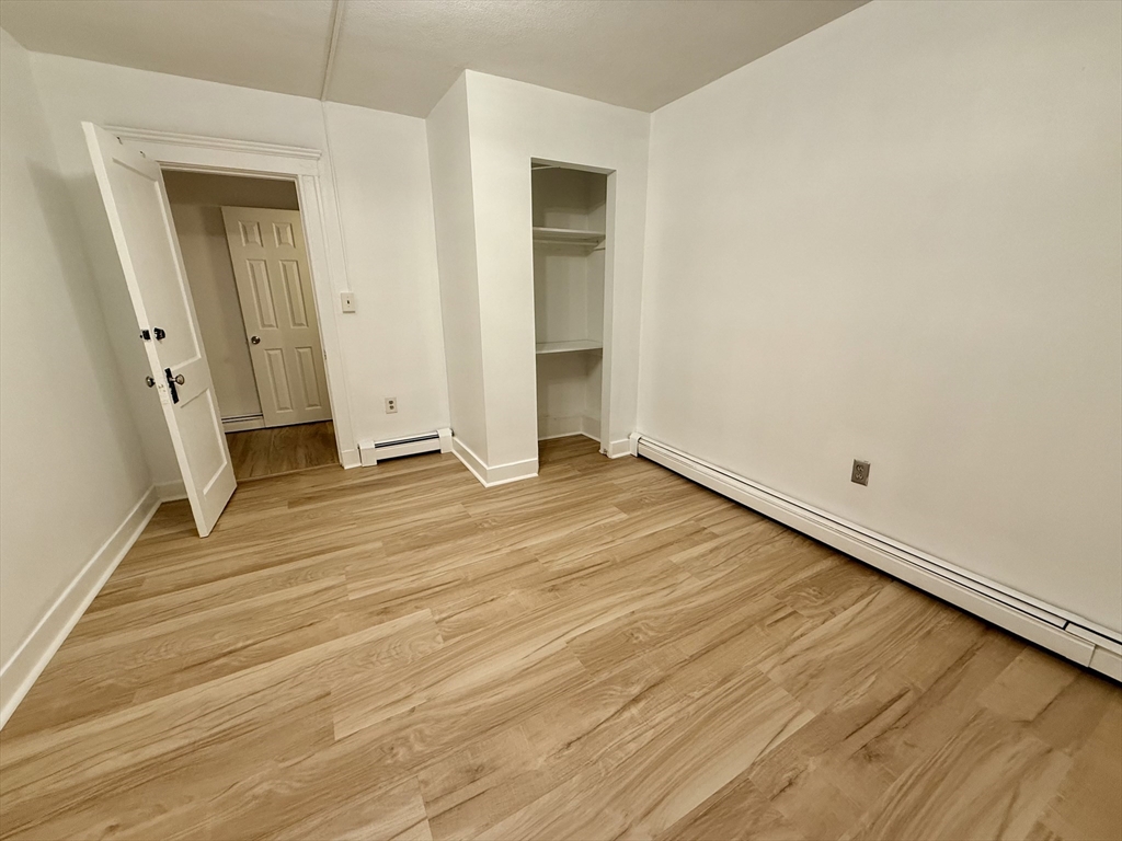 28 Ransom Road, Unit 12AB Boston, MA 02135 - Photo 13 of 17 an empty room with wooden floor and entrance
